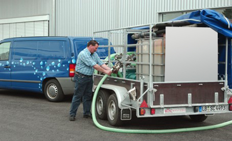 Mann schließt Verdunstungskühlanlage mit einem Schlauch an externe Umwälzpumpe an